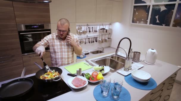 Affärsman matlagning och svara på telefonen — Stockvideo