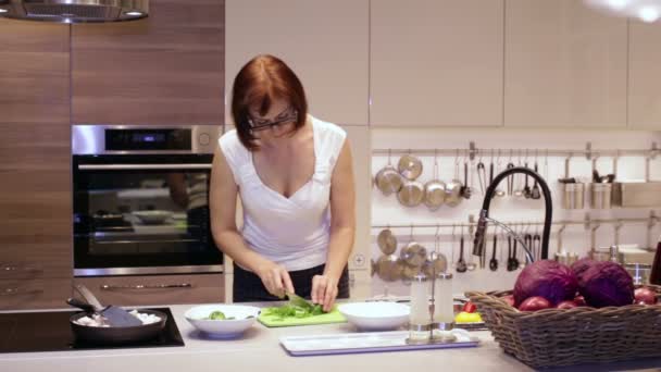 Vrouw bezuinigingen mes groene peper op het bord — Stockvideo