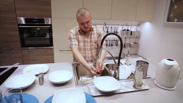 Homem está lavando pratos na pia da cozinha — Vídeo de Stock