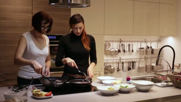 Frauen in der Küche bereiten Mittagessen zu. — Stockvideo