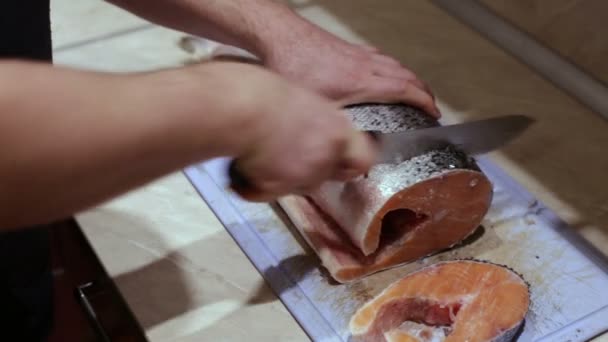 Man bezuinigingen de vis steaks op de keukentafel — Stockvideo