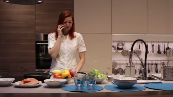 Mujer hablando en un smartphone en la cocina — Vídeos de Stock