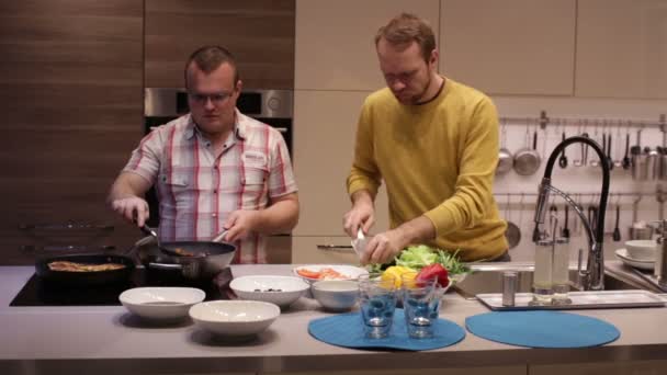 Hombres preparando la cena en la cocina y hablando — Vídeo de stock