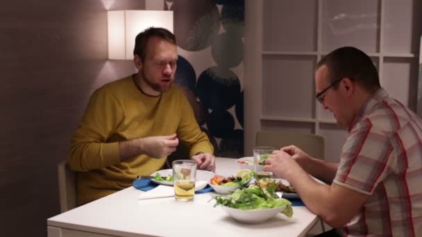 Män sitter vid bord, äta dricka öl och prata — Stockvideo