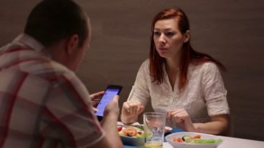 Kadın ve adam masada yemek yiyor olması.