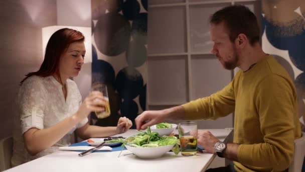 Frau und Mann essen zu Abend und unterhalten sich am Tisch. — Stockvideo