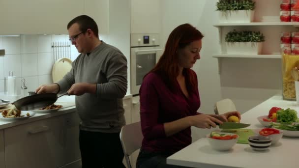 Una pareja preparando la cena en la cocina — Vídeos de Stock