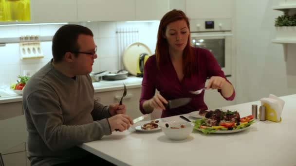 Un hombre con una mujer comiendo pollo y verduras — Vídeos de Stock