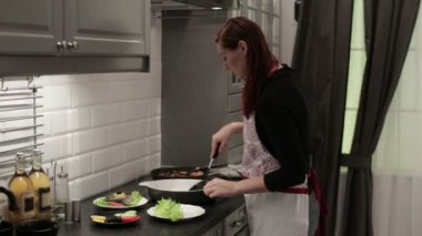 Kadın bir balık biftek bir tabağına koyuyor ve süsleyin