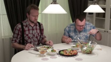 İki adam yemek ve konuşmak bir masada oturuyor