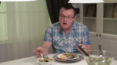 Man sitting at a table eating salad