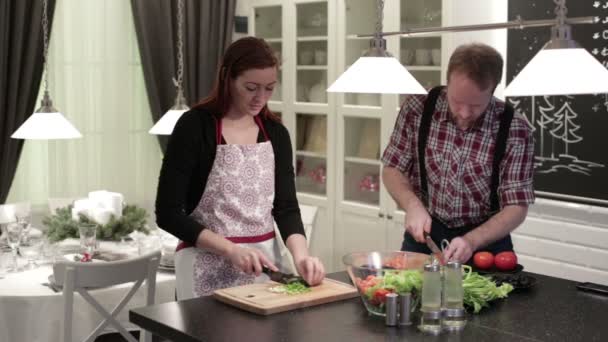 Молодая пара режет овощи на деревянных досках — стоковое видео