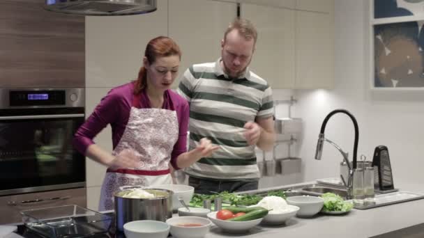 Чоловік і дружина вибрали трави на кухні — стокове відео