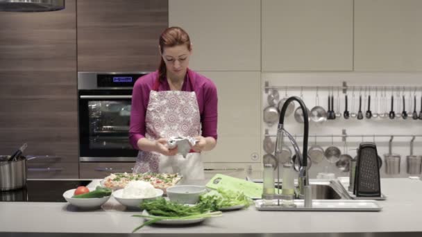 Женщина на кухне разворачивает фольгу для еды — стоковое видео