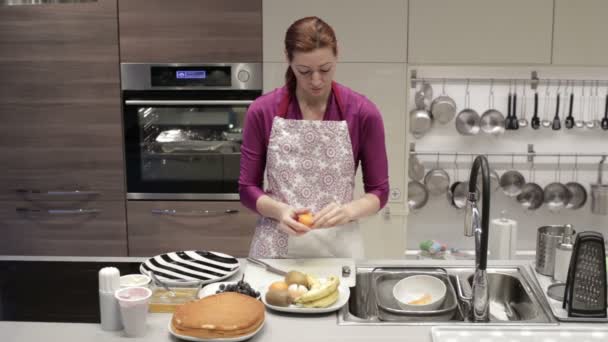 Una mujer limpia la cocina mandarina — Vídeo de stock