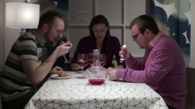 İki erkek ve kadın yemek ve konuşmak için masaya oturmak