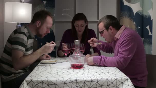 Men and woman sit at the table to eat and talk — Stock Video