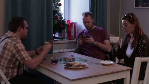 Freunde sitzen am Tisch und spielen Karten — Stockvideo