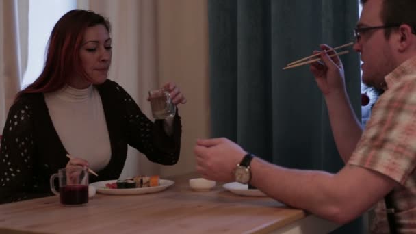 Echtpaar zitten aan de tafel eten sushi — Stockvideo