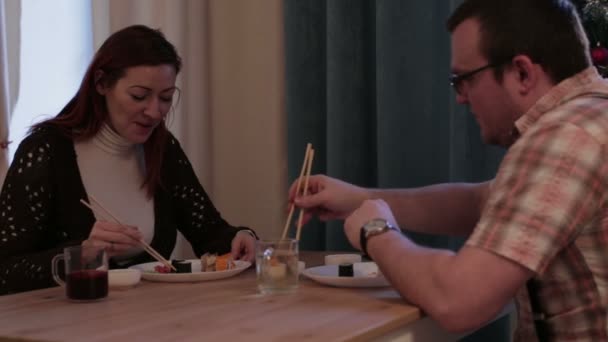 Mensen zitten aan de tafel eten sushi — Stockvideo