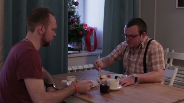 Männer essen Sushi am Tisch — Stockvideo