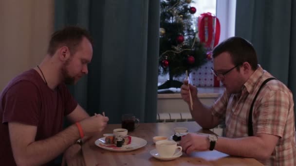 Zwei Männer essen Sushi am Tisch — Stockvideo