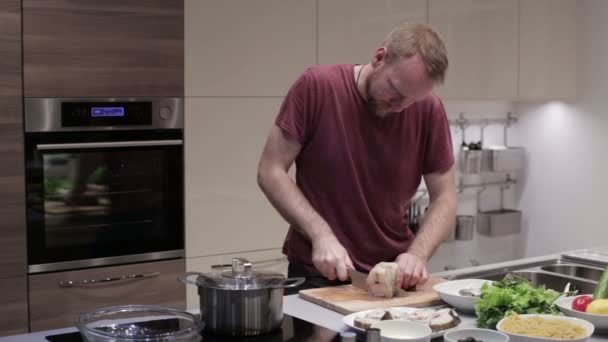 De man in de keuken knippen de vis in steaks — Stockvideo