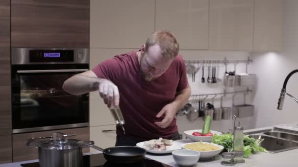 Mannen i köket förbereder fisk till stekning — Stockvideo