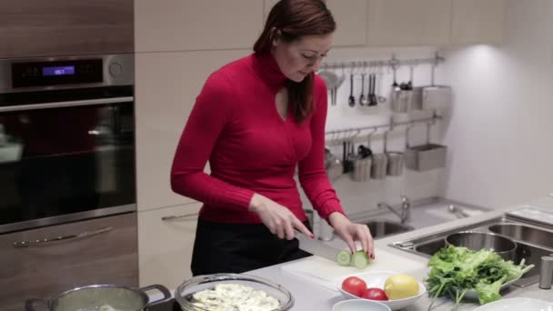 Die Frau in der Küche schnitt die Gurke — Stockvideo