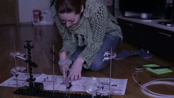 Женщина собирает дизайнера — стоковое видео
