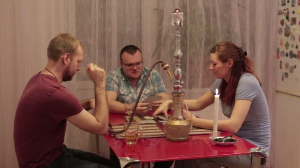 Gente divirtiéndose con una cachimba y jugando a las cartas — Vídeo de stock