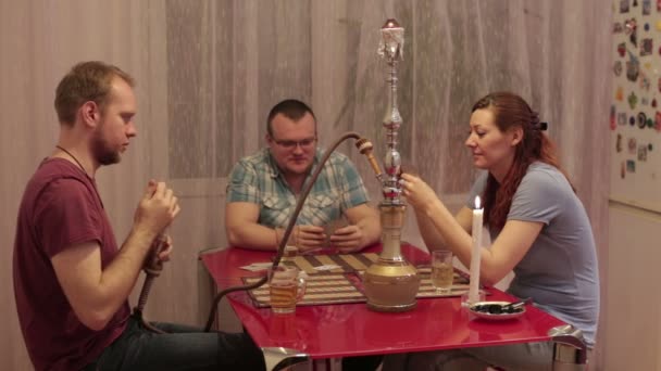 Men and woman smoking shisha and talking — Stock Video