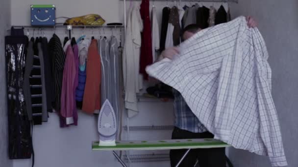 Мужчина гладит рубашку — стоковое видео