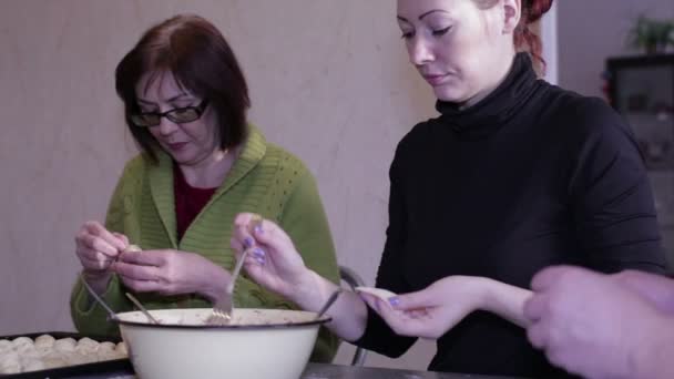 Young women mold dumplings at a table — Stock Video