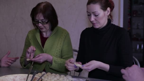 Glada kvinnor mögel dumplings vid ett bord — Stockvideo
