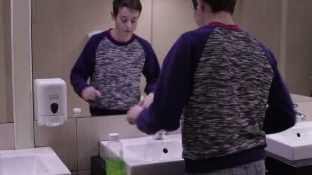 Tiener wast zijn handen met zeep in de gootsteen — Stockvideo