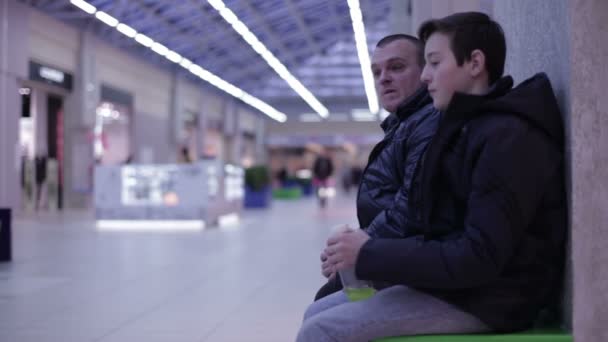 Adolescent parler avec un homme assis sur le banc — Video