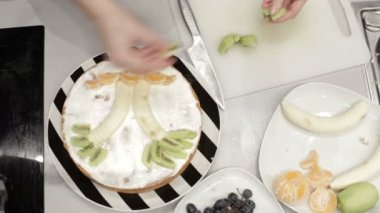 Kadın sünger kek meyve ile dekore edilmiştir.