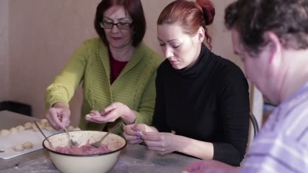 Family sculpts dumplings in the kitchen — Stock Video