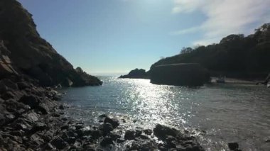 Galler 'in Pembrokeshire kıyısındaki Stackpole Quay limanına demirlemiş bir tekneyle kayalık bir gedik görülüyor..