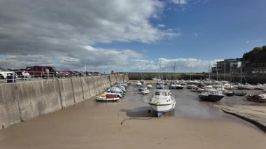Galler 'in Pembrokeshire kıyısındaki Saundersfoot limanına demirlemiş teknelerin hareketi yaz günü gelgitte.