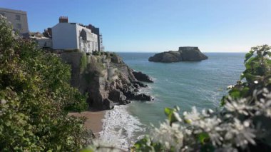 Galler liman kasabası Tenby 'nin güney sahilinde bir yaz günü, yüksek gelgitte St. Catherines Adası ile birlikte..