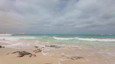 Atlantik Okyanusu dalgaları Cape Verde adası Boa Vista 'nın volkanik bir kaya kıyı şeridini aşıyor..