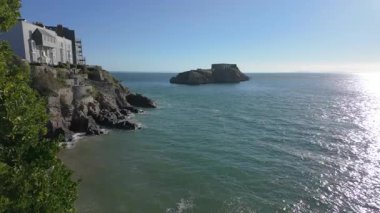 Tenby Güney Sahili 'nde, gelgitte St Catherines Adası' yla aydınlık güneşli bir günde..