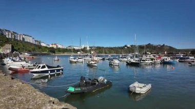 Gal liman kenti Tenby 'ye demirlemiş gemilerin hareket hızı parlak bir yaz gününde.