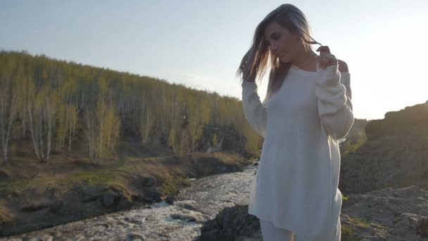 Girl stands on a rock on a background of the river — Stock Video