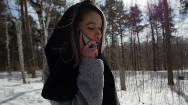 Tjej prata i telefon promenader i skogen — Stockvideo