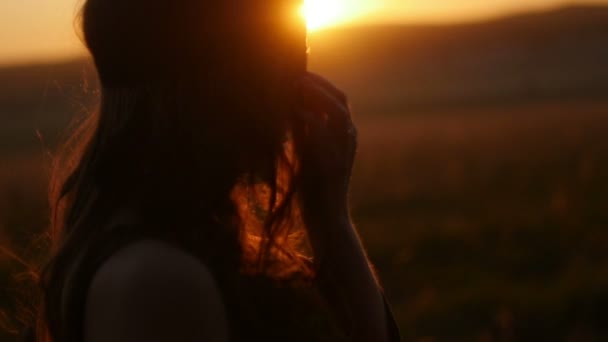 Menina posando ao pôr do sol no campo — Vídeo de Stock