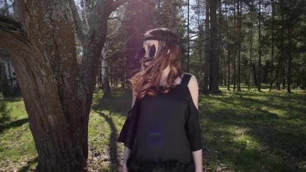 Mooi meisje in een zwarte jurk wandelingen in het bos — Stockvideo