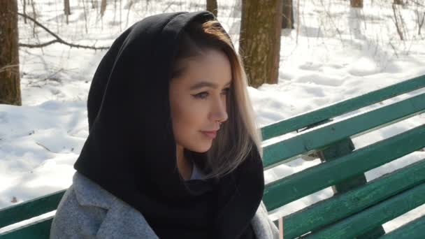 Ung flicka dricka kaffe i en winter park sitta på bänken — Stockvideo